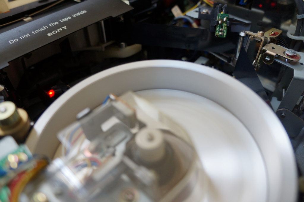 Inside of U matic tape machine with label 'do not touch the tape inside'