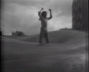 A child stands on top of an inflatable structure, black and white image.
