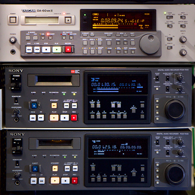 enlarged image shows 4 rack-based professional tape machines with multiple buttons, dials and digital displays