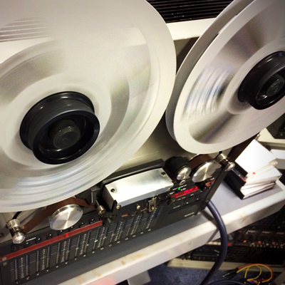 oblique angle view of half inch tape machine with reels spinning