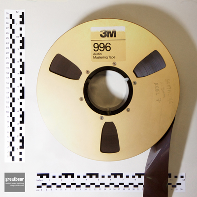 Large gold-coloured spool with 2 inch brown magnetic tape and rulers indicating dimensions