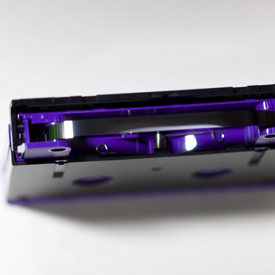 view from tape end of purple cassette shell, showing black magnetic tape