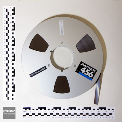 Aluminium Ampex spool with half inch brown magnetic tape and rulers indicating dimensions